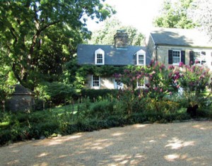 A house with many flowers growing in the yard.